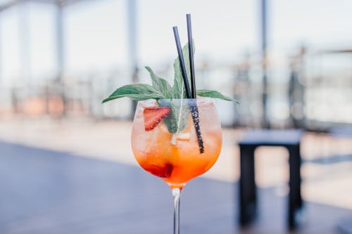 Cocktail Drink with Strawberry and Herb Garnish