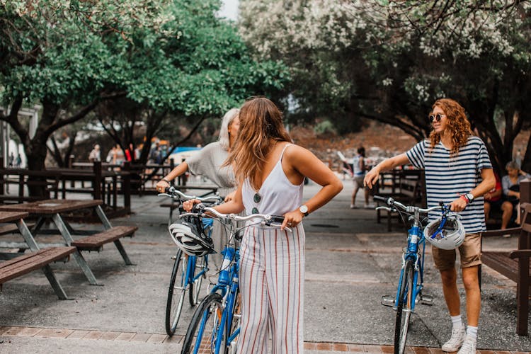 Friends Walking Together With Their Bikes