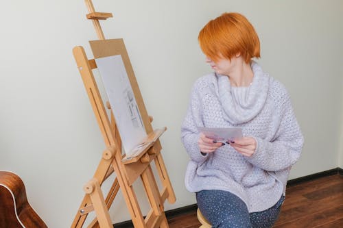 Woman in White and Gray Sweater Sitting on Brown Wooden Chair