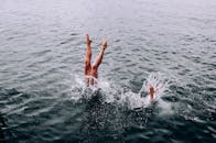 一个人潜入水中的令人兴奋的镜头，创建一个动态飞溅和展示充满活力的运动.