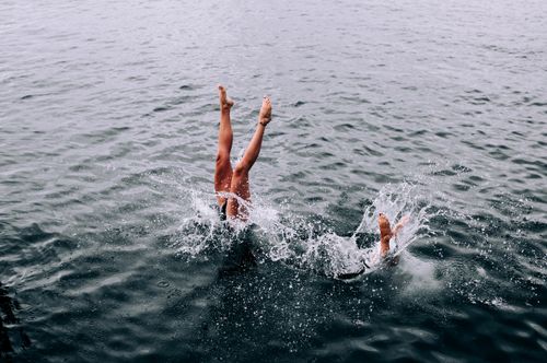 Free Exciting shot of a person diving into water, creating a dynamic splash and showcasing energetic movement. Stock Photo