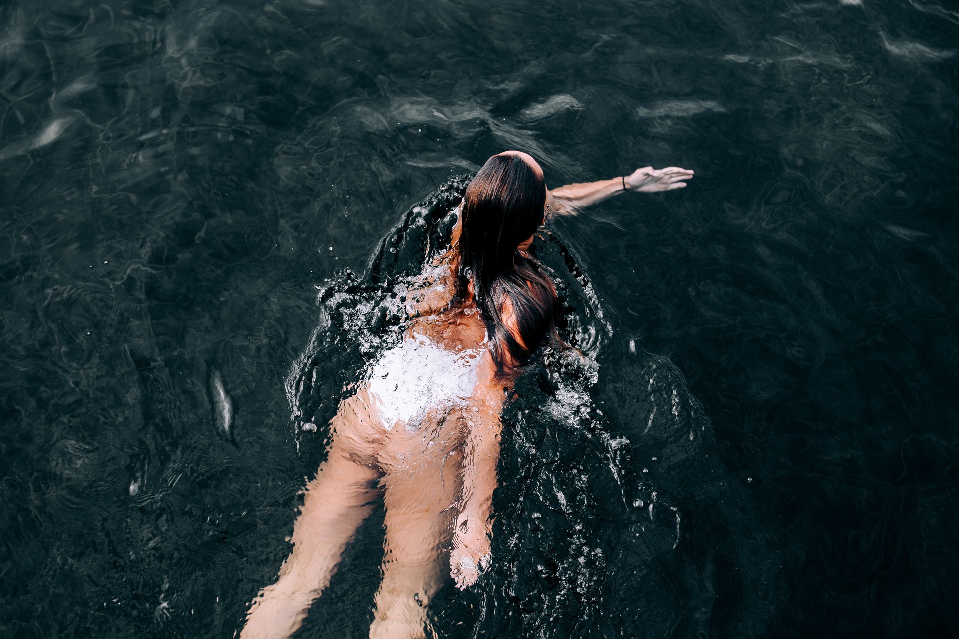 Photo of a Woman Swimming in Deep Waters