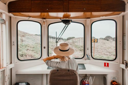 Free Back view of a woman with straw hat on a scenic train ride. Stock Photo