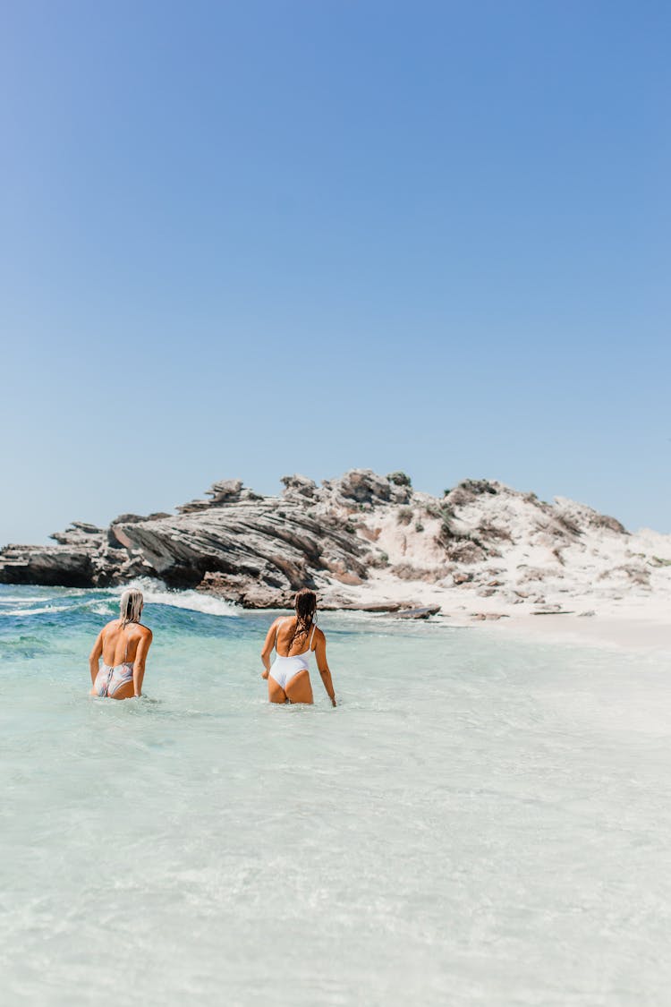 Two Women In Swimsuits Bathing In The Sea In Summer