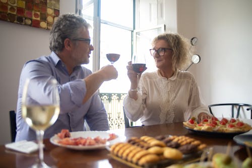 Man and Wom with Glasses of Red Wine at Dinner