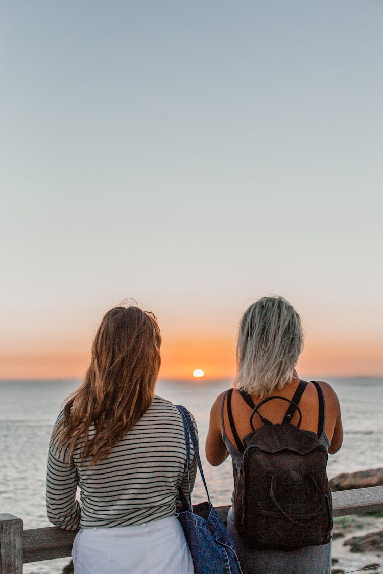 Women Looking At Sunset Over Sea