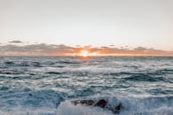 迷人的海洋日出，壮观的天空和汹涌的海浪