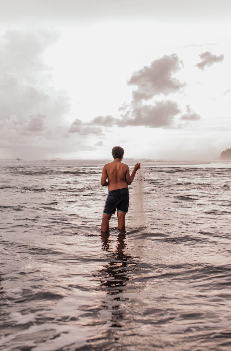 Man Standing Ankle Deep In Sea 