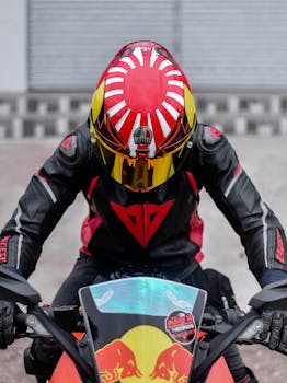 Motorcycle racer in colorful helmet and gear, captured in action for motorsport enthusiasts.
