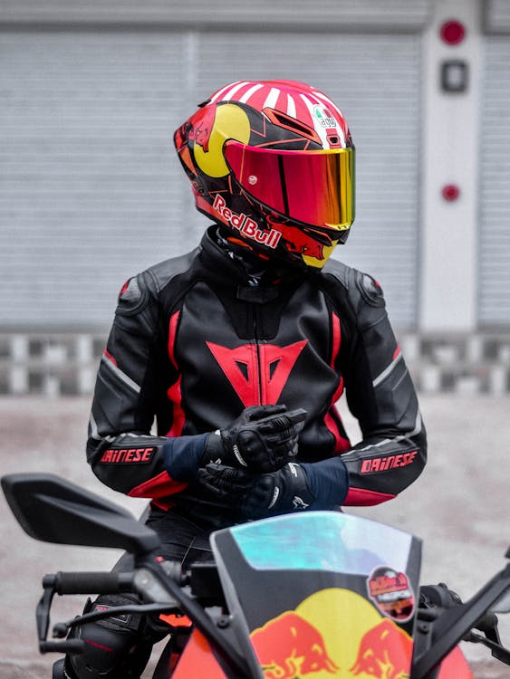Imagen recortada del motociclista en jeans y botas de cuero con casco