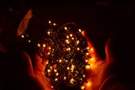 双手轻轻握着发光的圣诞灯，为节日增添了热烈的气氛