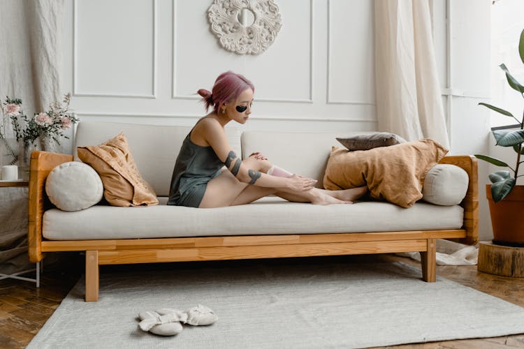 A Woman Waxing Her Legs Using A Wax Strips