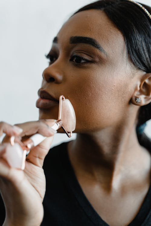 A Woman using a Jade Roller