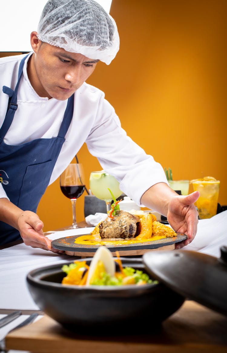 A Man Putting A Dish On The Table