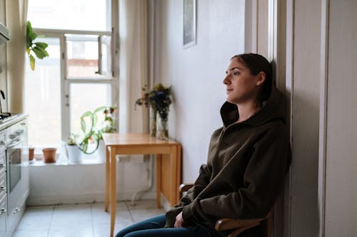 Free Photograph of a Woman in a Hoodie Sitting Stock Photo
