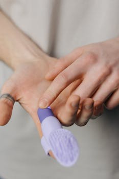 A detailed view of a purple finger vibrator being held and used for massage.