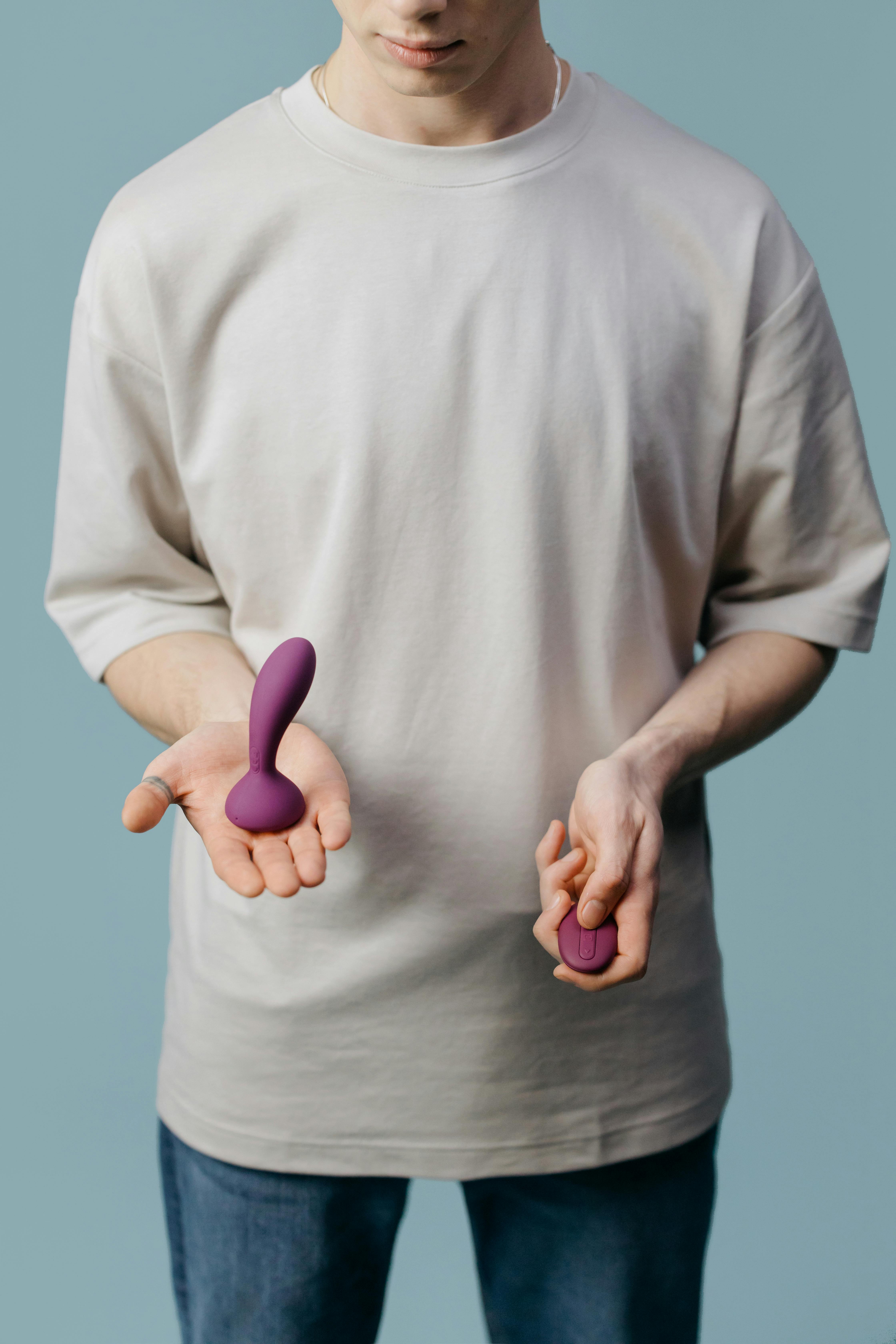 man in beige shirt holding a sex toy