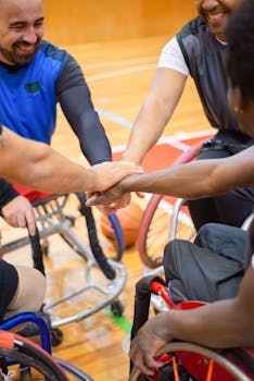 A diverse group of wheelchair basketball players united in a huddle indoors, emphasizing teamwork.