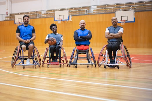 Four wheelchair basketball players posing on an indoor court, showcasing team spirit.