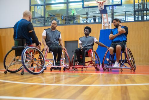 Free Wheelchair basketball players strategize during a game, showcasing inclusivity and sportsmanship. Stock Photo