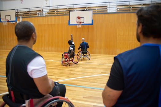 Players in wheelchairs enjoying a competitive basketball game on an indoor court.