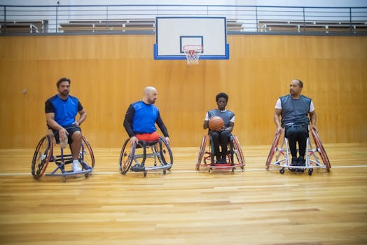 Four men in wheelchairs on a basketball court preparing for a game, demonstrating teamwork and skill.