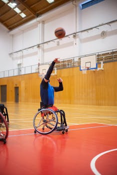 An athlete in a wheelchair playing basketball indoors, showcasing skill and determination.