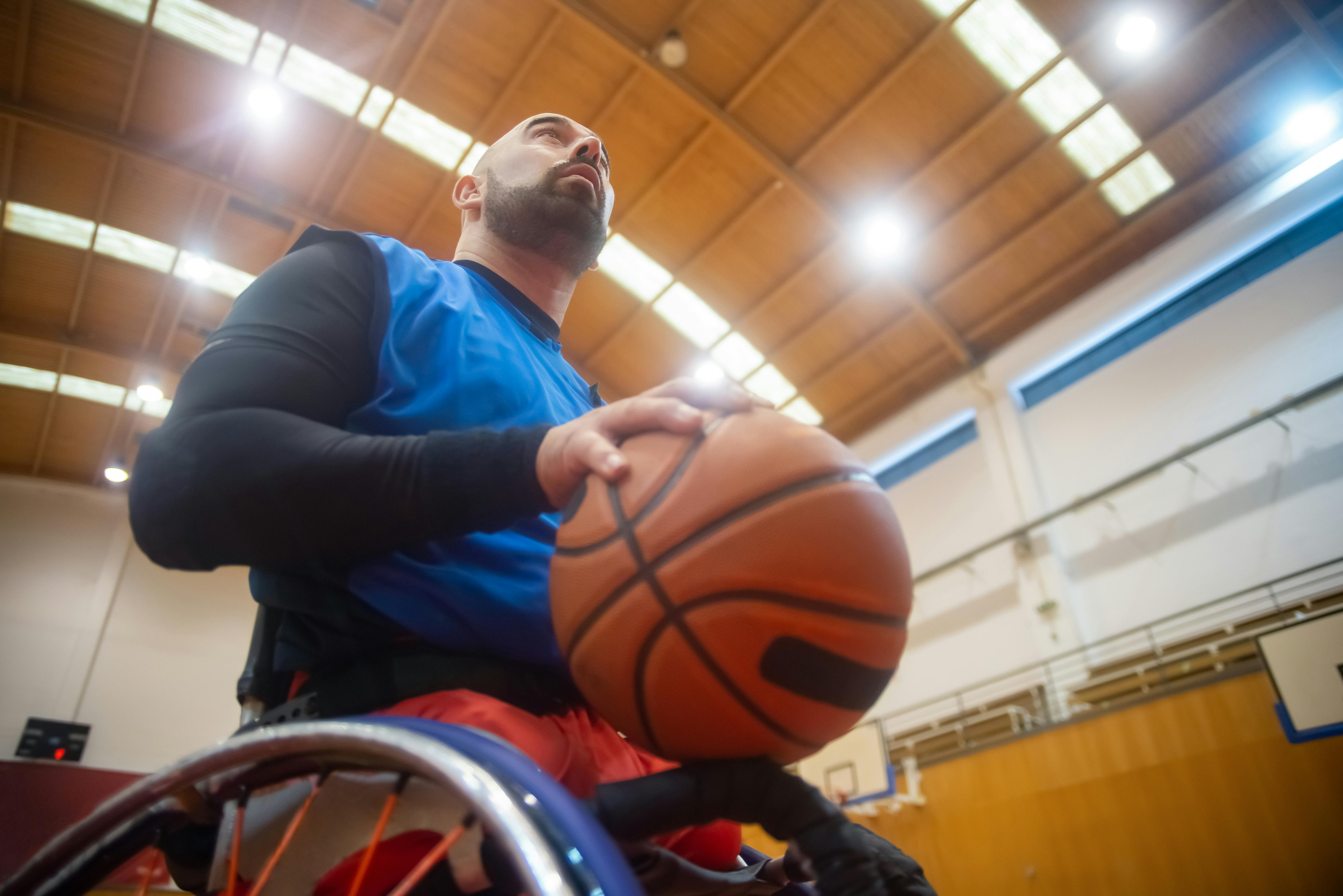 NCAA Basketball photo featuring Wheelchair basketball player focused and ready for the game indoors in a sports hall.