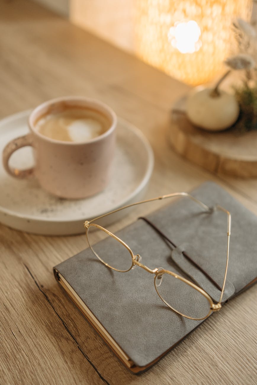 Aesthetic scene of a cup of coffee next to an open journal