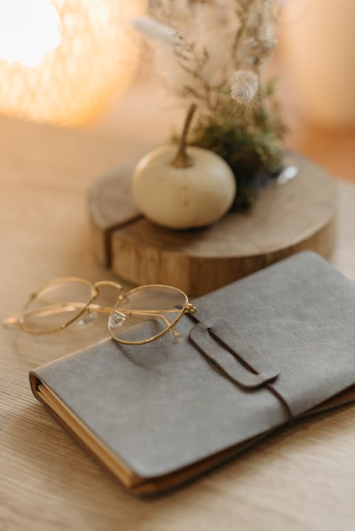 Gold Framed Eyeglasses on Gray Book