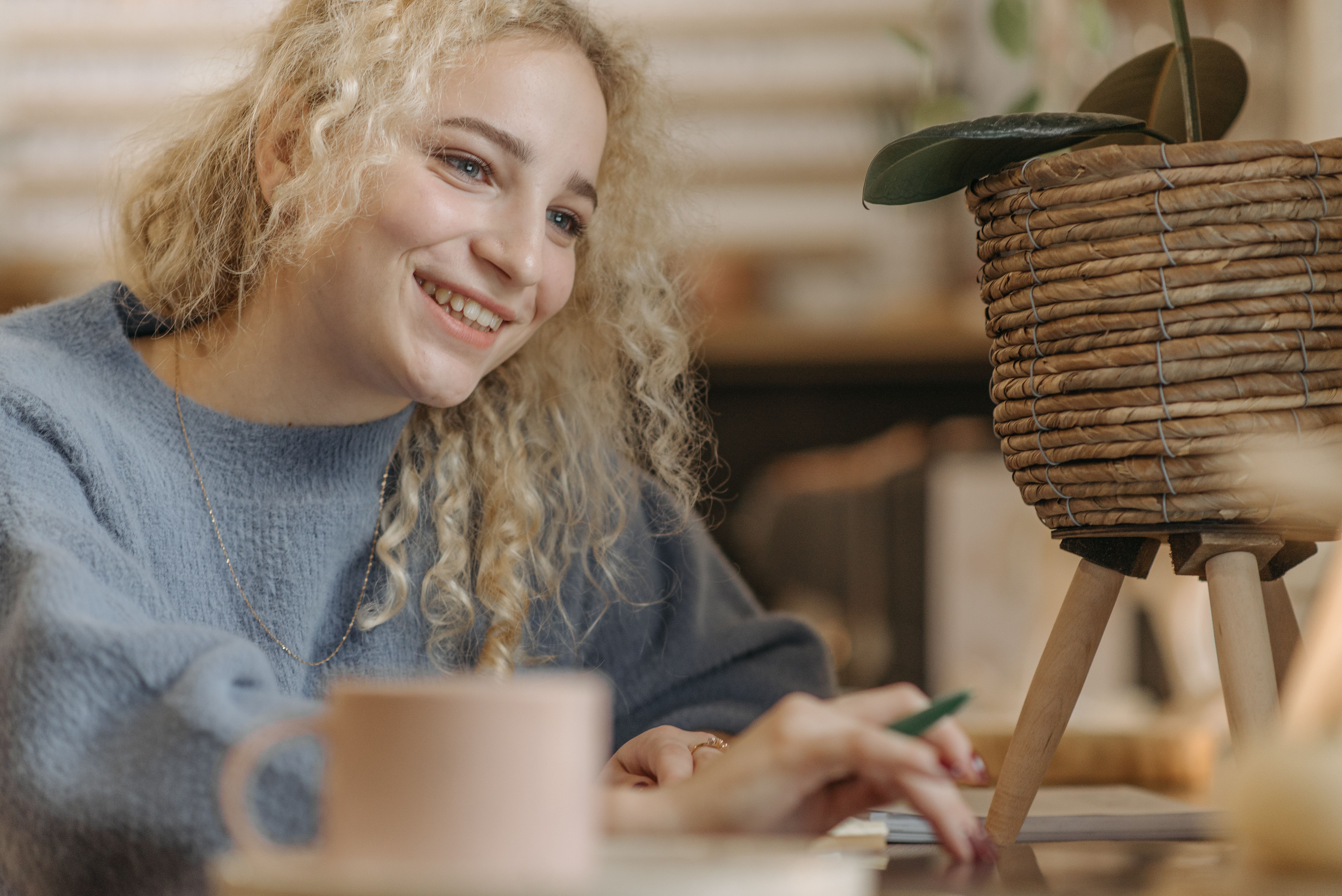 A person smiling while working from a hammock or a cozy coffee shop — showing that work can be enjoyable