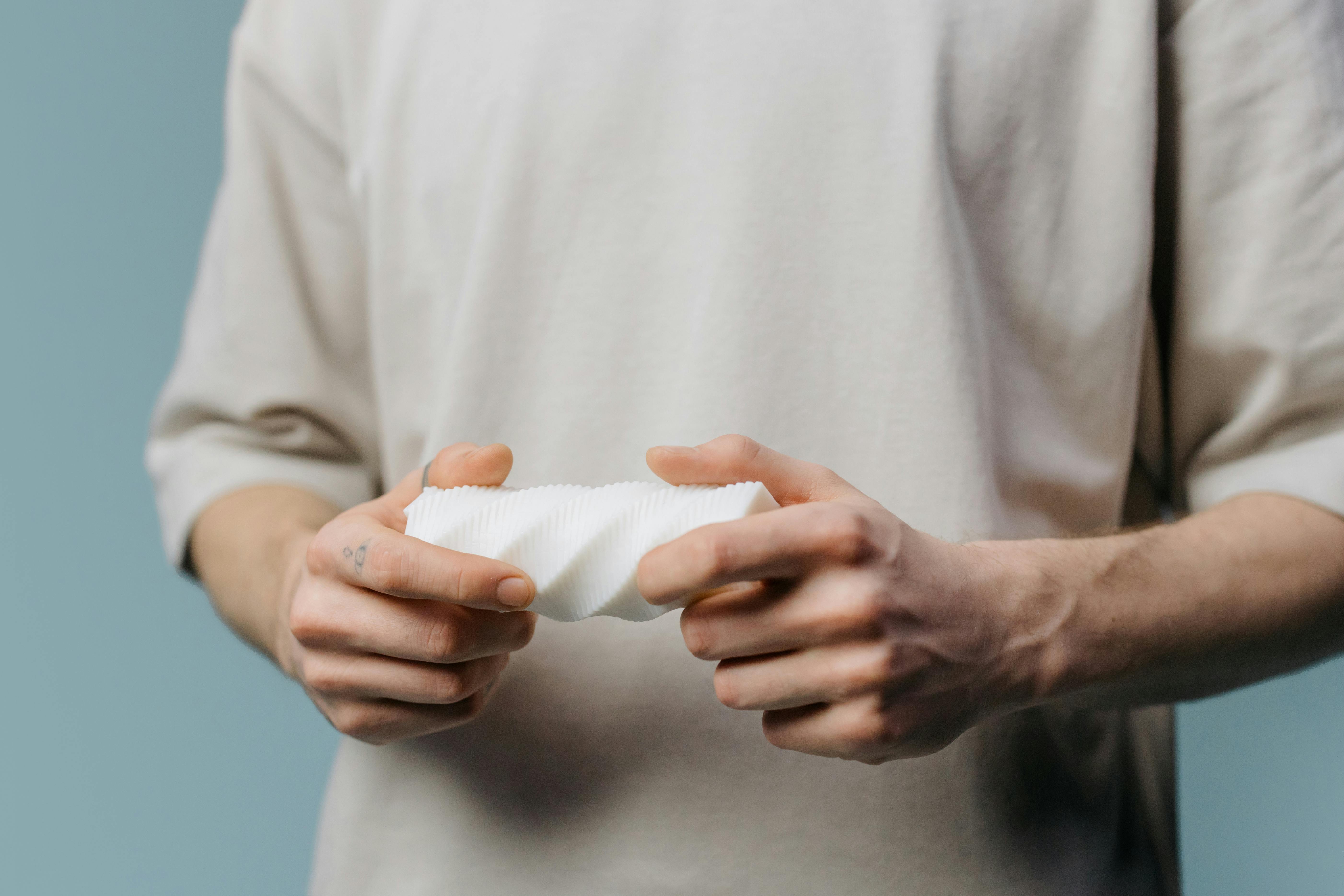 close up shot of a person holding a white sex toy