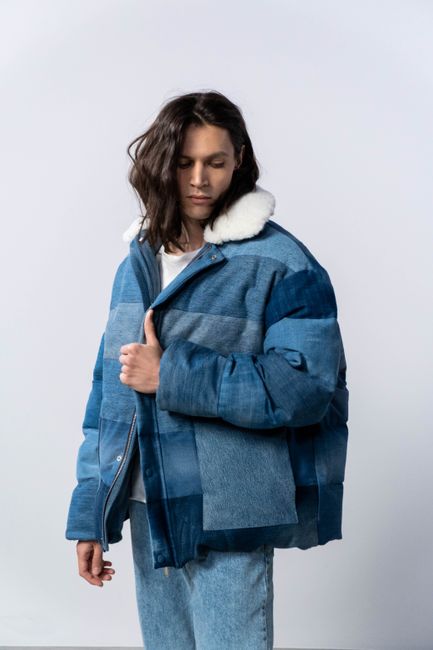 Man posing in casual denim attire, featuring stylish outerwear.