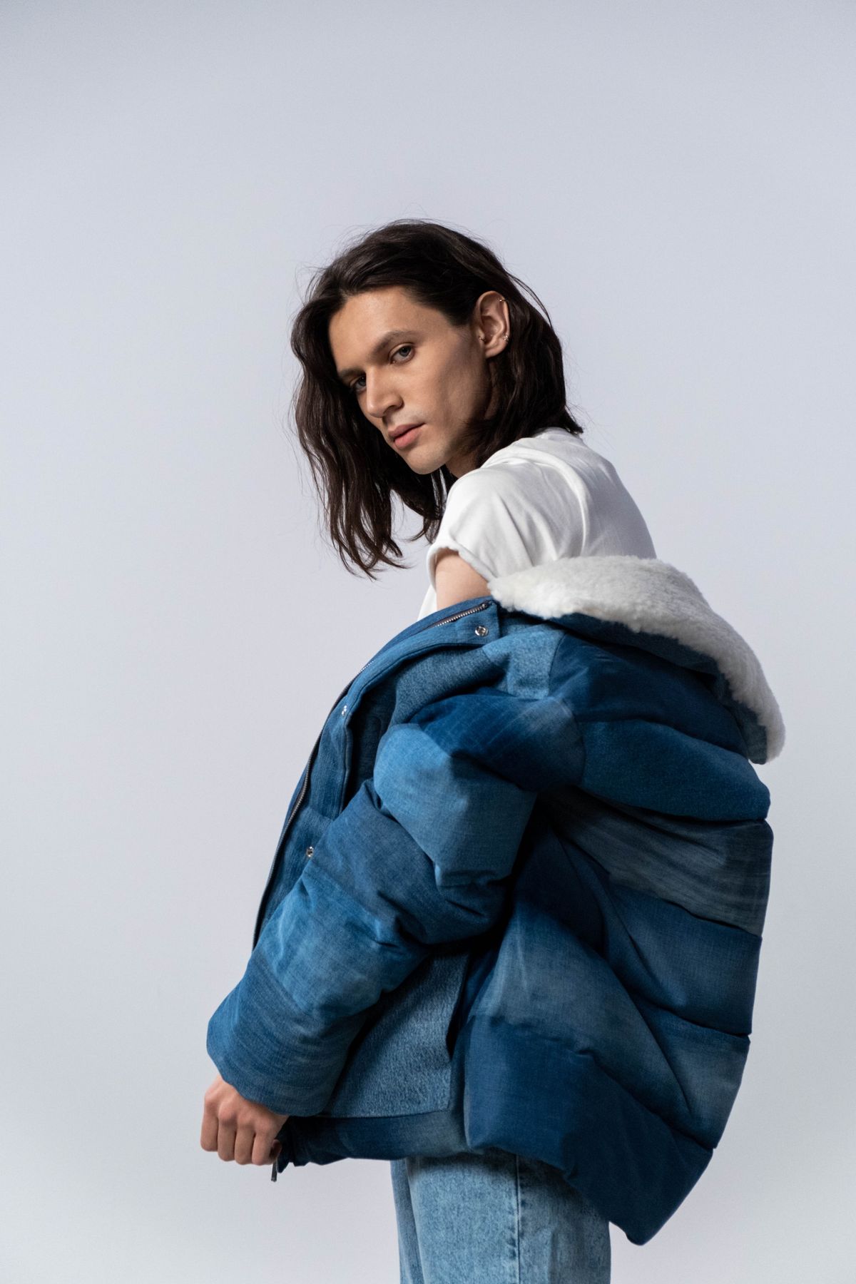 Model wearing an oversized blue insulated jacket in a studio — photo by cottonbro studio on Pexels