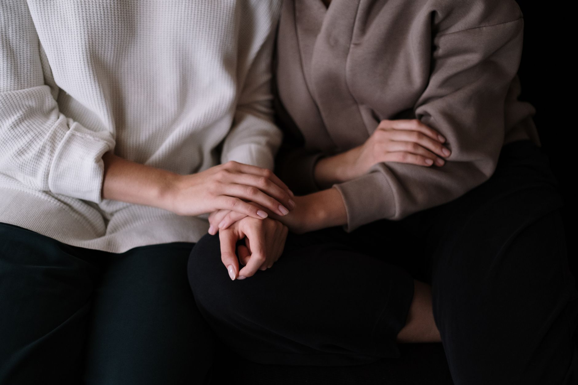 Two people sitting together, one offering quiet reassurance