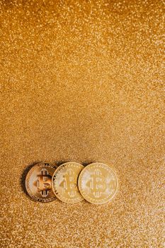 Three Bitcoin coins on a shimmering gold background, ideal for finance or cryptocurrency themes.