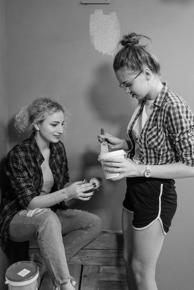 Black And White Photography Of Young Women Painting A Room