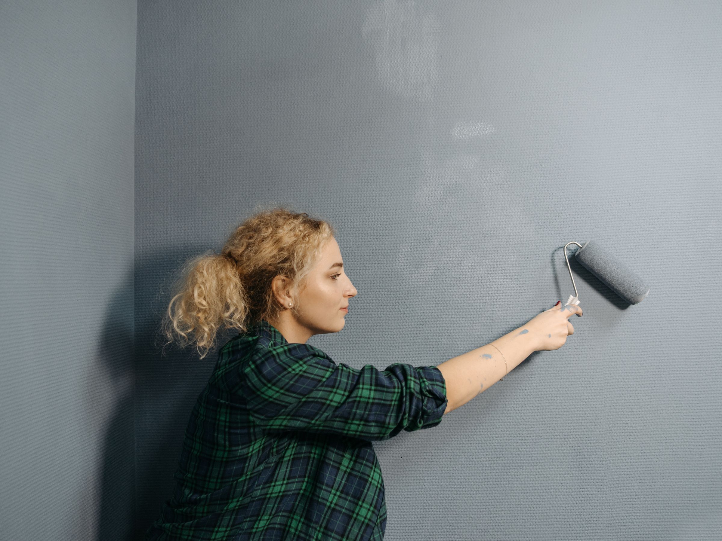 Professional decorator applying fresh paint to a wall with a roller