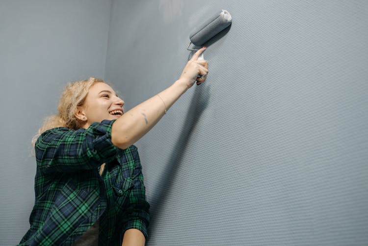 Woman Painting Wall With A Paint Roller