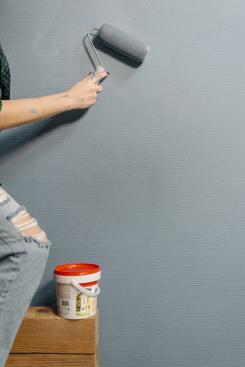Free Person Painting Wall with a Paint Roller Stock Photo