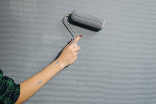 Person Painting Wall with Paint Roller