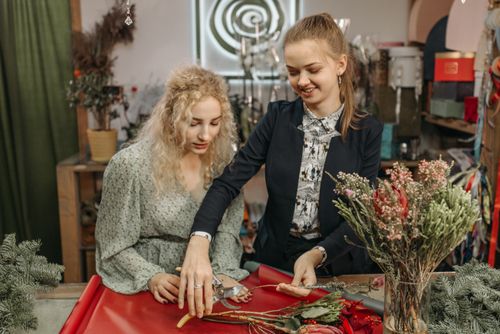 Free Two women arranging flowers in a florist shop, focusing on teamwork and creativity. Stock Photo