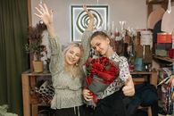 Woman in Gray Long Sleeve Shirt Standing Beside Woman in Black and White Floral Dress