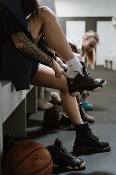 Female athletes putting on sneakers in an indoor changing room.