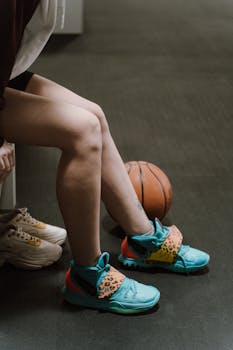 A sportswoman prepares for the game in a changing room, showcasing her colorful sneakers.