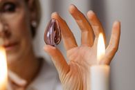 Person Holding Lighted Candle in Front of Person