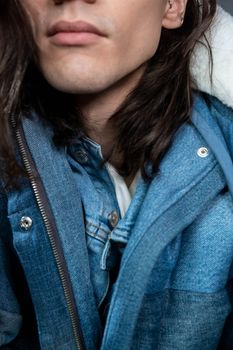A close-up view of a person in a stylish denim jacket, showcasing a modern fashion look.