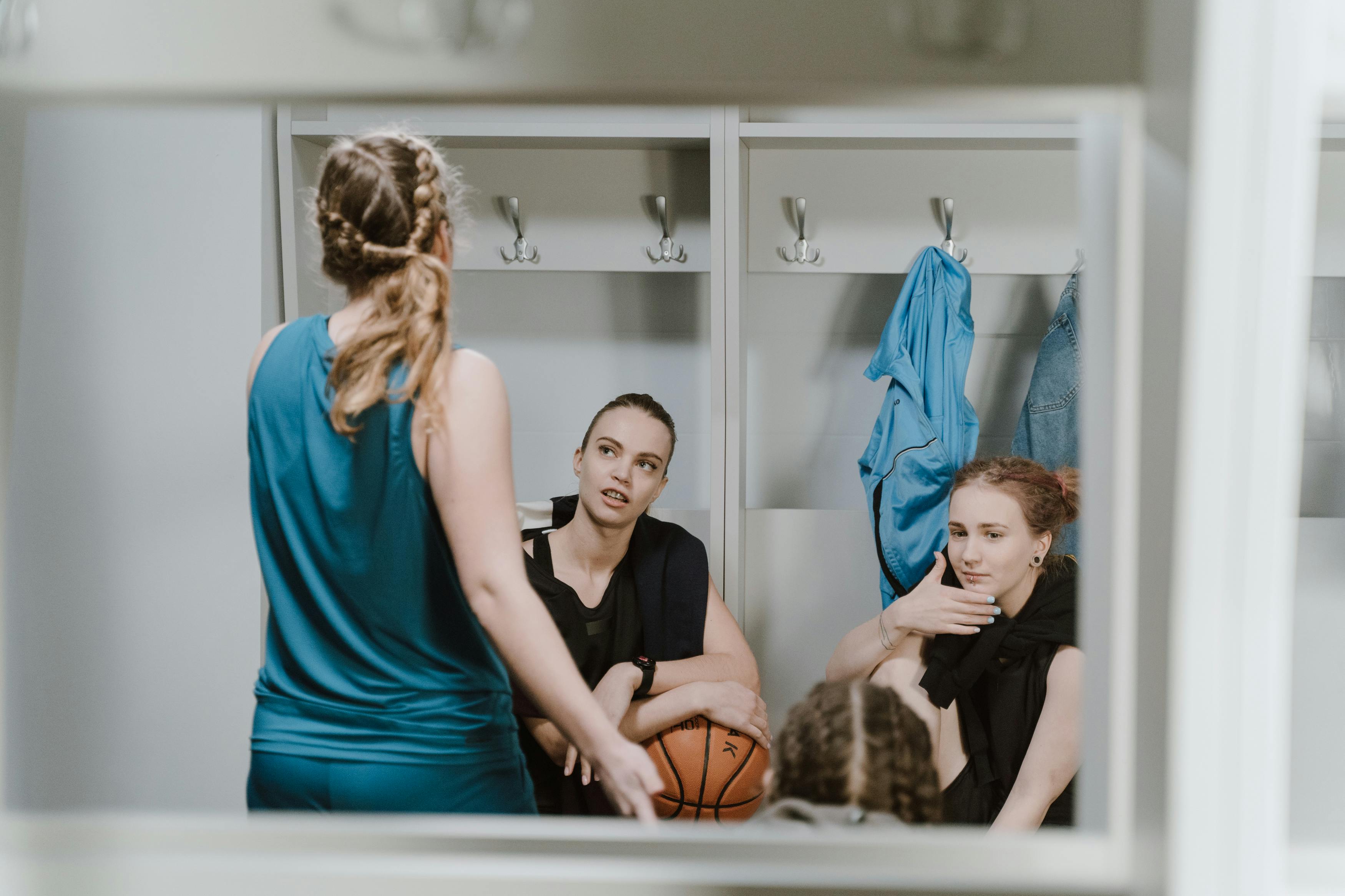 woman in teal tank top and black pants sitting on brown wooden chair