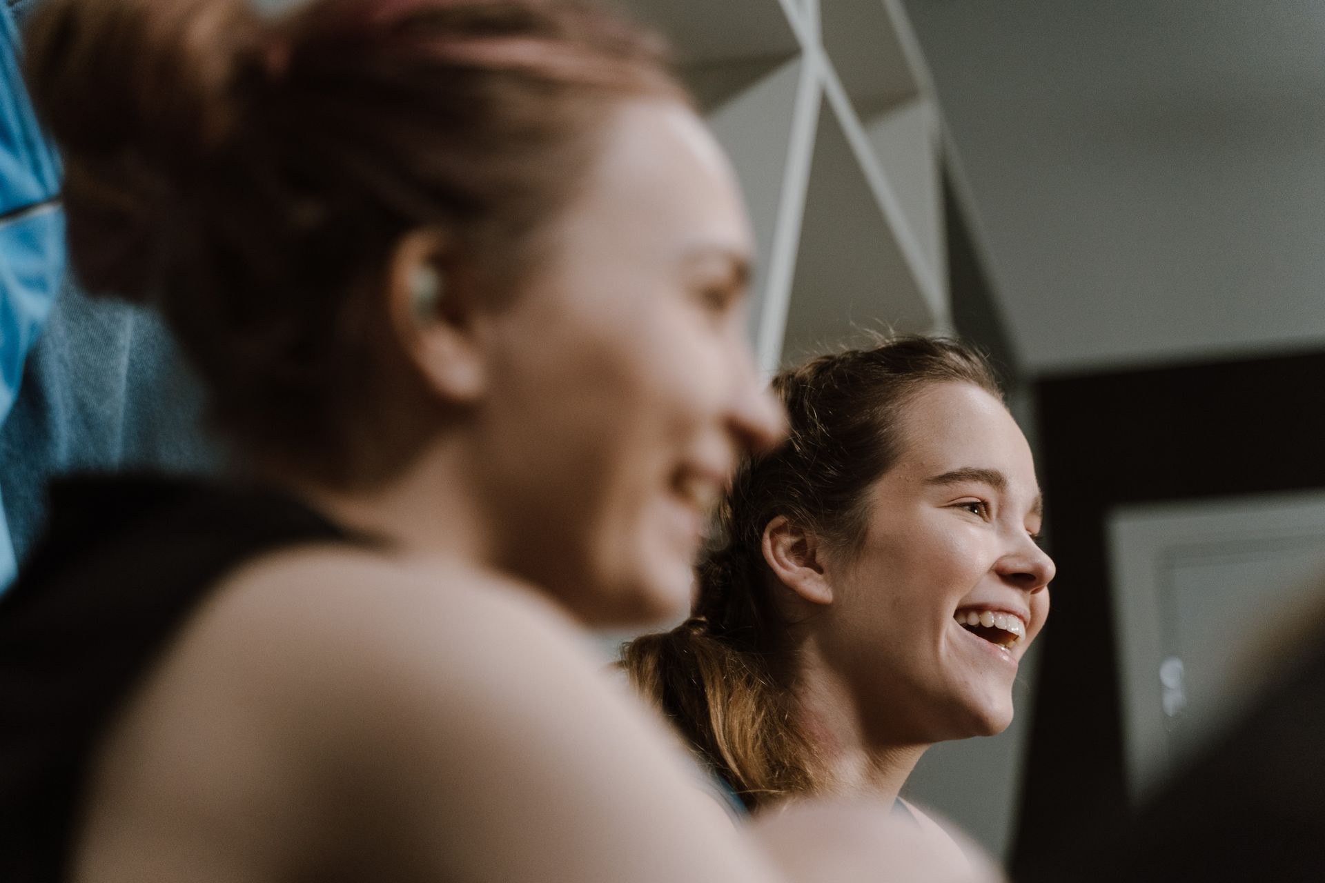 Close-up of two women smiling and enjoying their time together indoors.