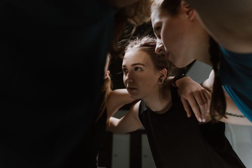 Free A determined sports team huddling in unity, preparing for a game indoors. Stock Photo